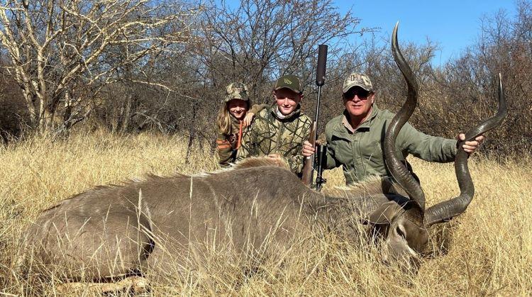 Man and two children posing with a kudu bull shot in South Africa