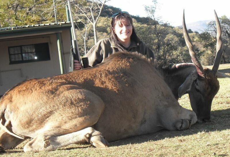 female posing with female cow she shot
