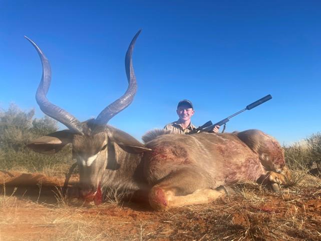 Teenage boy posing with harvested kudu.