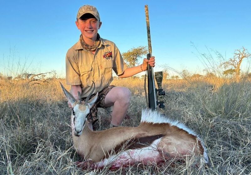 A close up shot of a boy posing with his trophy springbok he shot